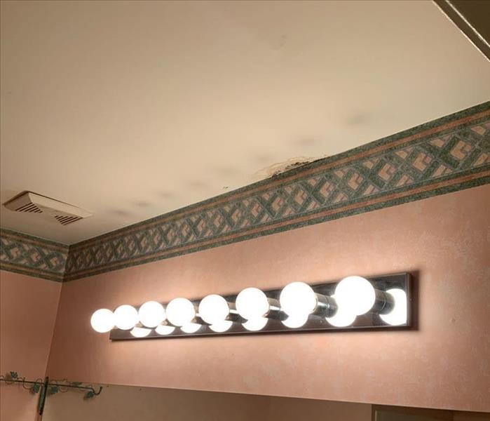 Bathroom ceiling with Hollywood lights and small water stains on the ceiling