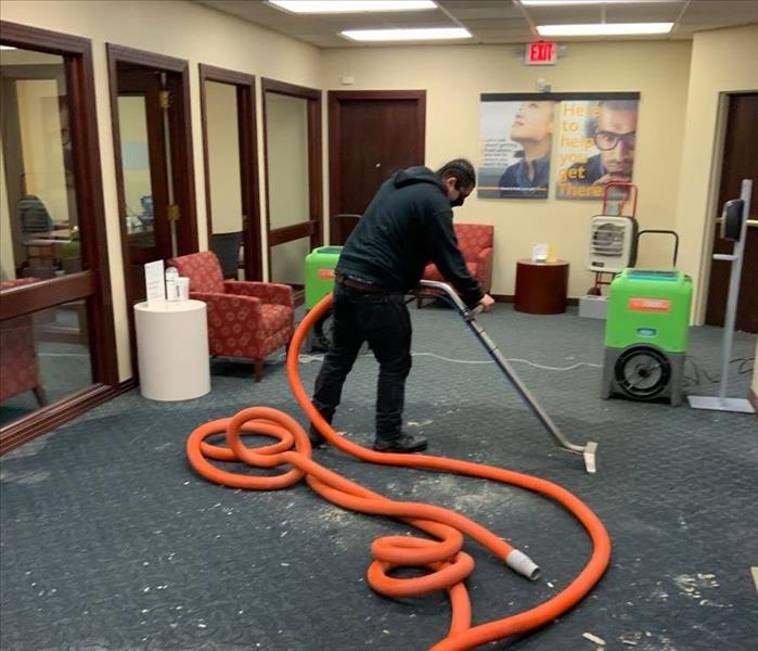 SERVPRO technician with water removal equipment in an office