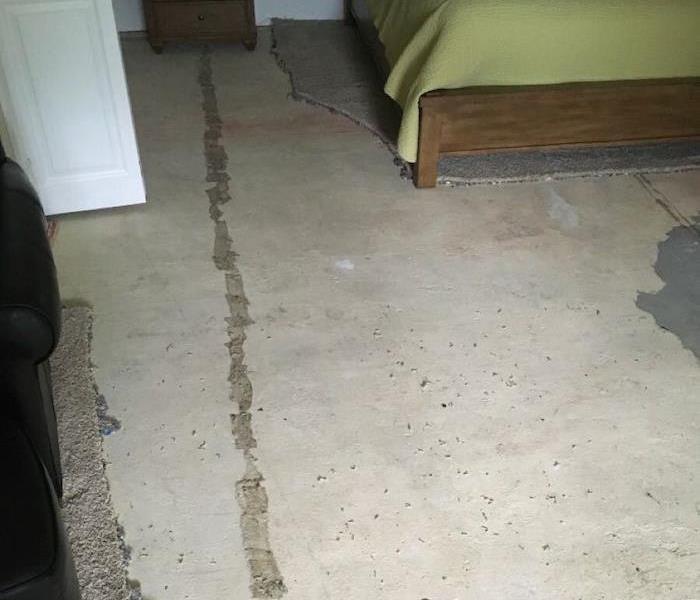 Bedroom with partially removed carpet