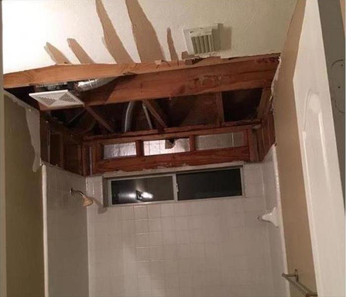 A bathroom with the ceiling drywall removed. 