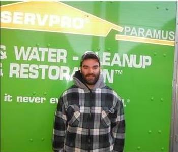 A man standing in front of a SERVPRO van.