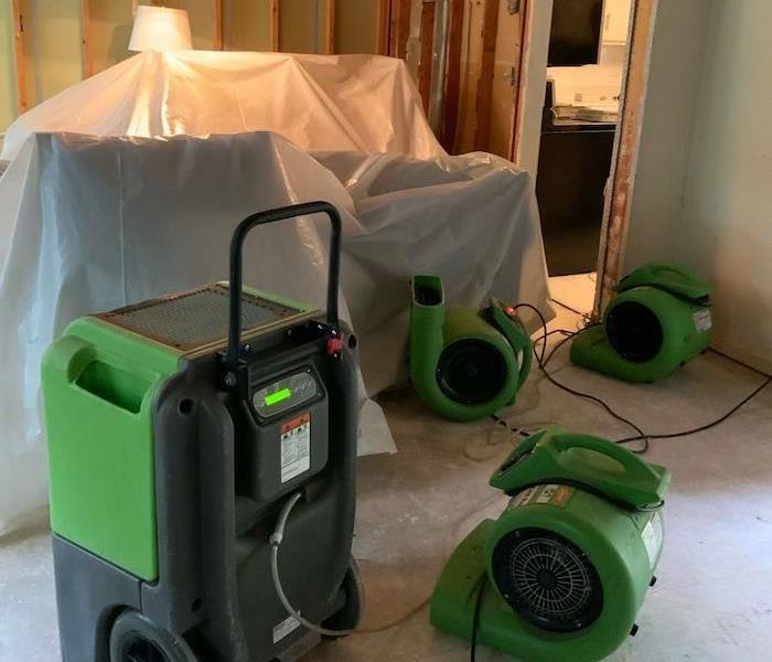 Room with exposed framework and SERVPRO drying equipment
