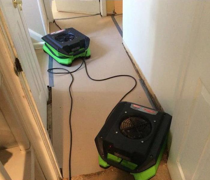 SERVPRO drying equipment on paper barrier in hallway