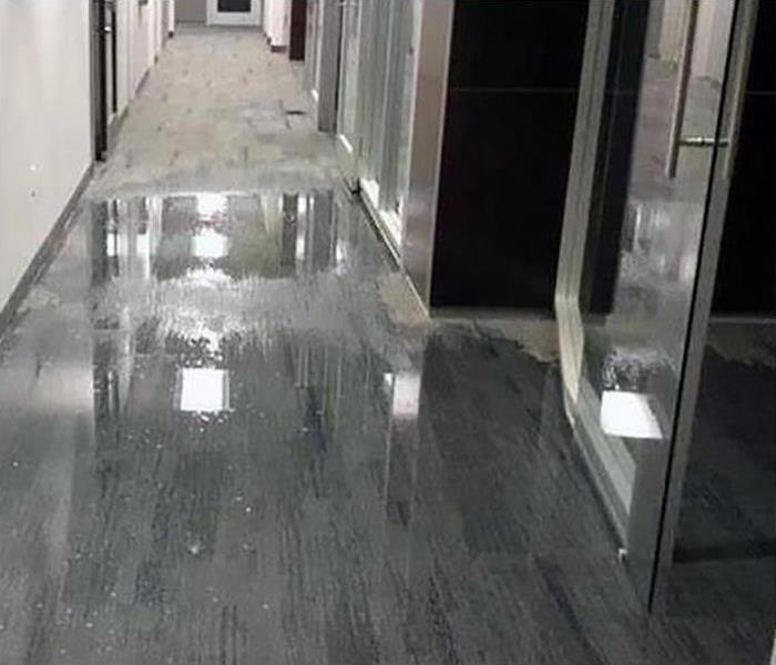 Standing water on grey flooring of an office. 