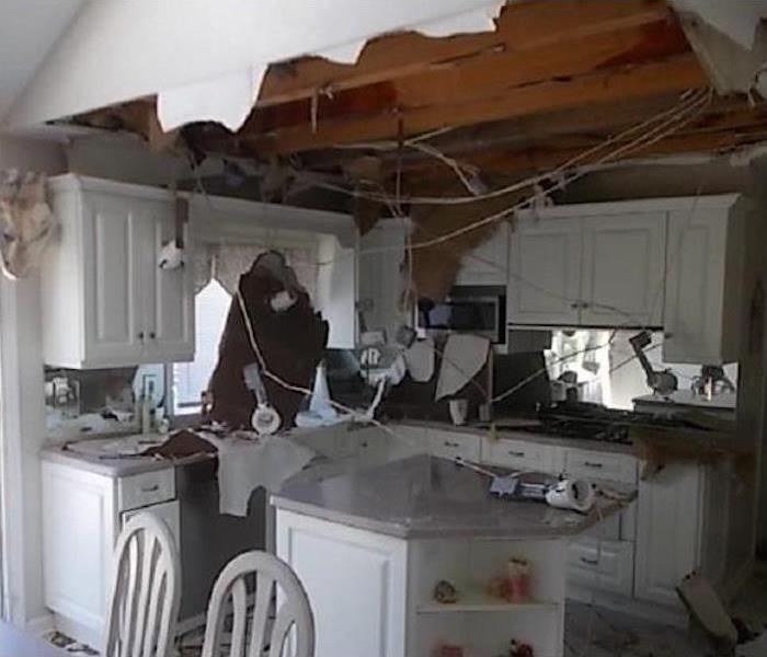A kitchen with a ceiling that has fallen through. 