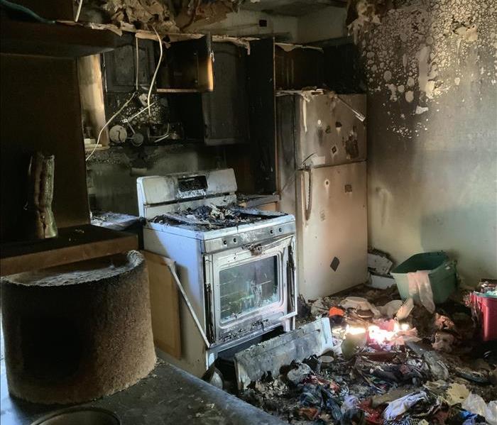 A kitchen with a large amount of fire damage. 