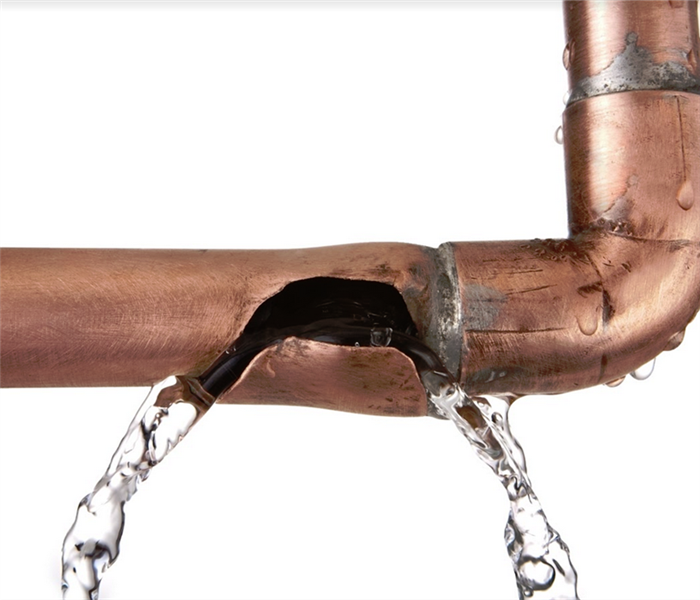 water leaking out of a burst copper pipe