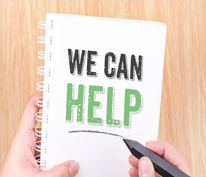 A notebook with the words " WE CAN HELP" on it. 