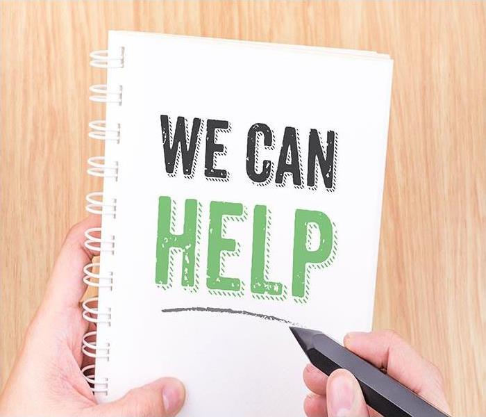 A notebook with the words " WE CAN HELP" on it.