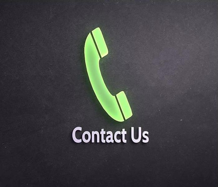A black background with a green phone with the words " Contact Us" on it. 